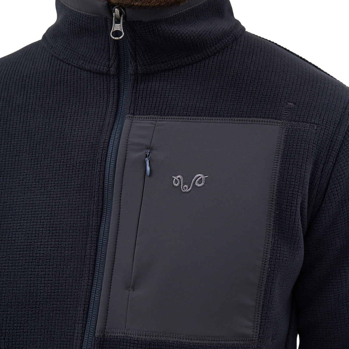 Brusttasche einer Anthrazit-farbenen Jacke aus Merinowolle und Polarfleece-Polyester