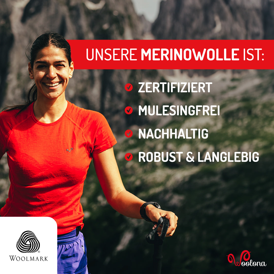 Lächelnde Frau trägt ein zertifiziert mulesingfreies und nachhaltiges T-Shirt aus 100% Merinowolle.