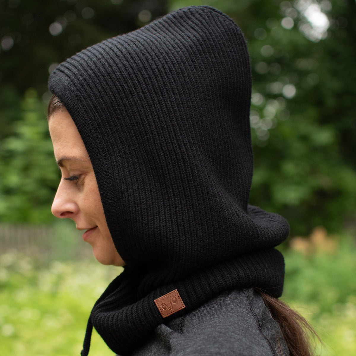 Die Frau trägt einen Kapuzenschal in schwarz.