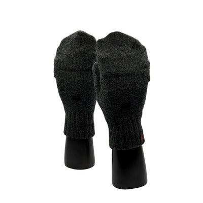 Zwei Hände mit Fäustlingen aus Merino in Anthrazit und Finger geschlossen mit Woolona Logo