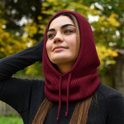 Dame trägt einen Merino Kapuzenschal in der Farbe Burgundy Rot