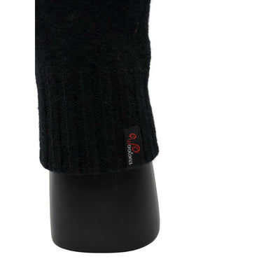 Aus der nähe eine Hand die ein Handschuh aus Merinowolle in Schwarz trägt und das Woolona Logo zeigt