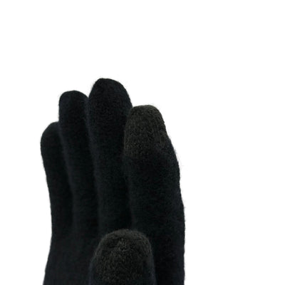 Aus der nähe eine Hand die ein Handschuh aus Merinowolle in Schwarz trägt und die Fingerspitzen zeigt die Touchscreen-fähig sind