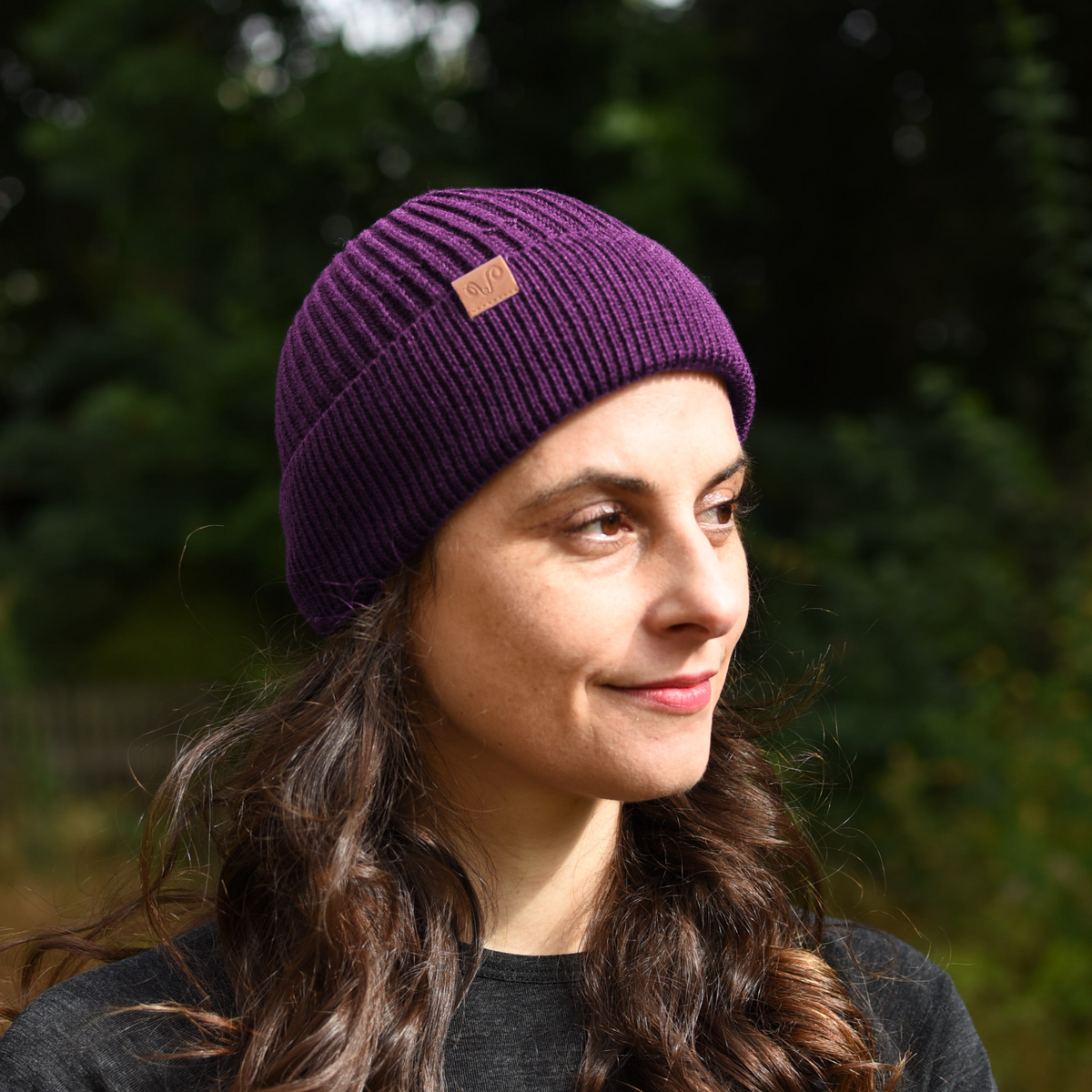 Frau mit einer violett farbenen Merino Mütze 