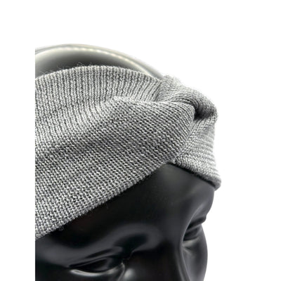Aus den Nähe ein Stirnband aus Merino in Grau auf einem Puppenkopf das den Knoten zeigt