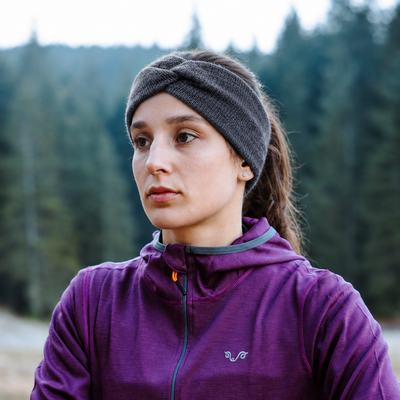 Nahaufnahme eines anthrazitfarbenen Merino-Stirnbands von Woolona mit gedrehtem Frontdetail an einer Frau.