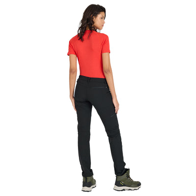 Frau mit schwarzer Trekkinghose aus Merino und orangen Shirt von hinten. 