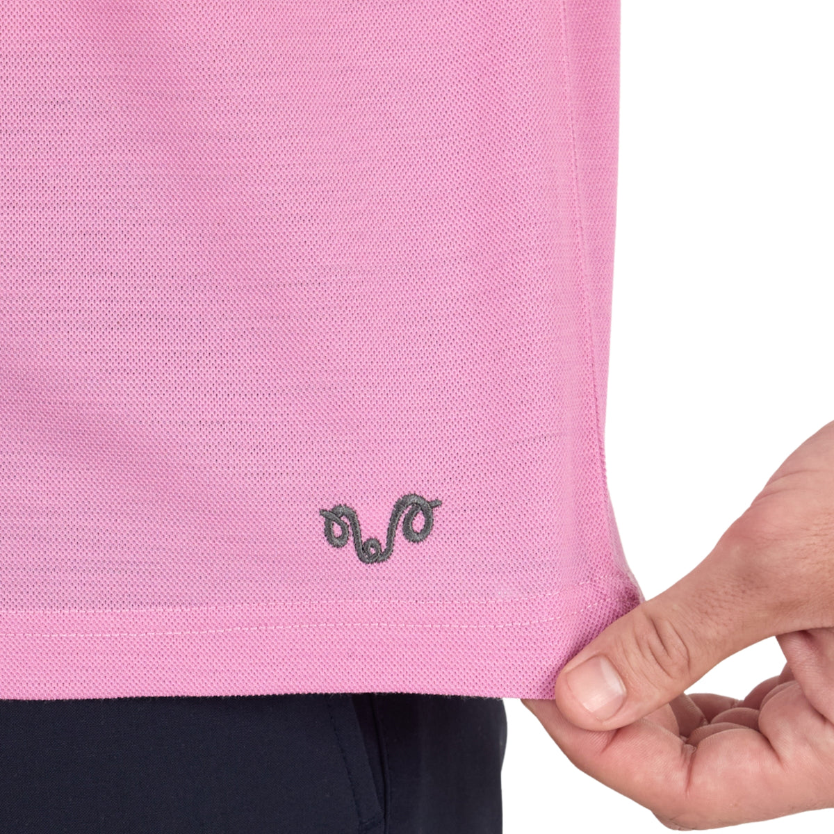 Pique Poloshirt aus Merinowolle in der Farbe pink aus der Nähe fotografiert mit grauem Logo. 